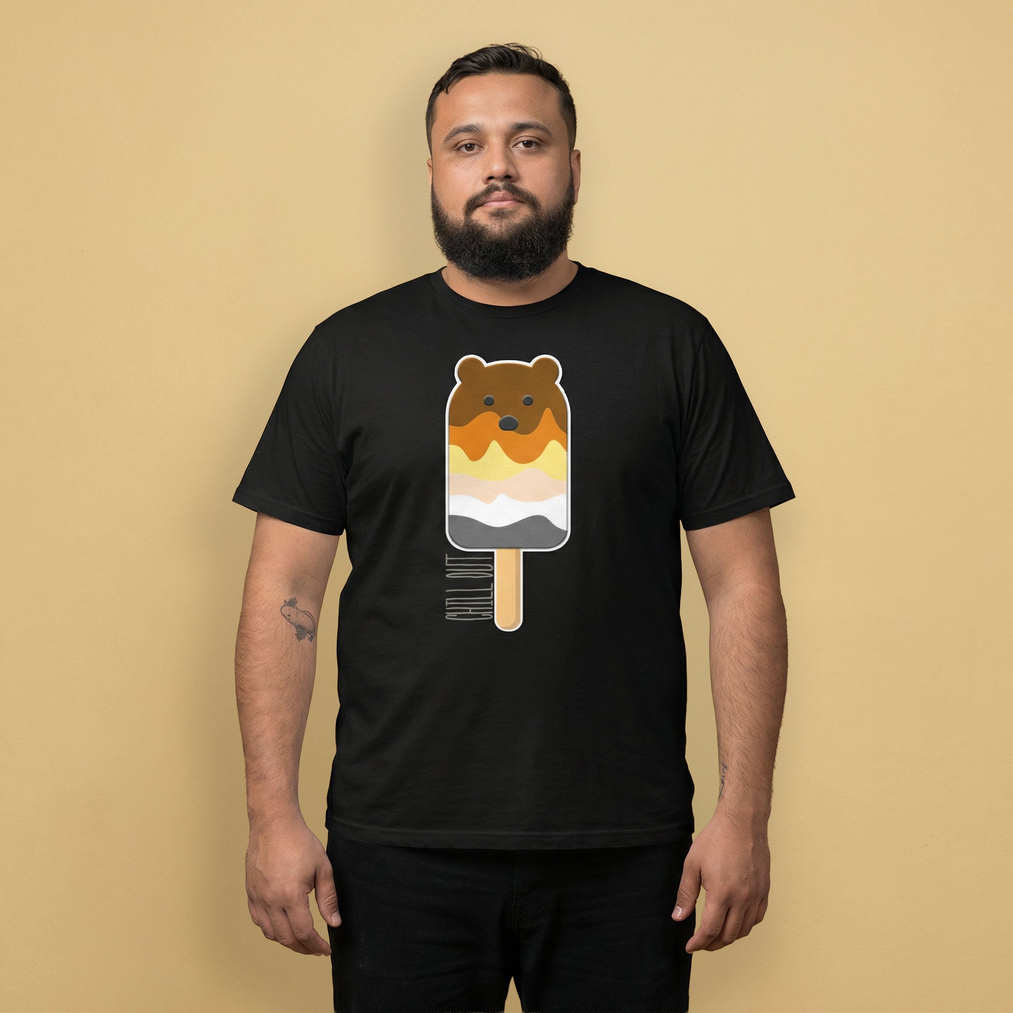 Man wearing a black t-shirt with a bear popsicle graphic on a beige background - Bear Paddle Pop T-Shirt – Gay Bear Pride Flag Parody Tee – LGBTQ+ pride t-shirts US UK – Gay pride shirts collection – Made-to-order gay apparel