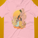 Pink shirt featuring a sunset with two silhouetted figures, one sitting sucking the one standing, surrounded by cacti - Vintage Brokeback Cowboy t-shirt - western gay pride tee by BackRoom Gear