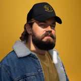 A gay bear wearing a black cap with a yellow pig graphic and the text 'Happy Little Piss Pig' on a yellow background - Black Happy Little Piss Pig trucker cap - watersports kink pride hat by BackRoomGear