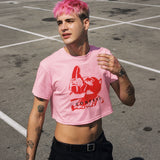 Gay twink wearing a pink Confess Crop Sniff Test, a bubblegum pink crop top worn at LGBTQIA+ Pride in an outdoor setting