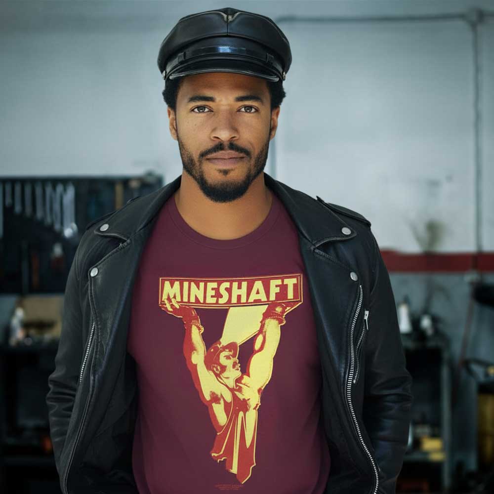 Man wearing a maroon t-shirt with 'Mineshaft' graphic design in a workshop setting - Retro LGBTQ+ pride t-shirts US UK – Gay pride shirts collection – Made-to-order gay apparel