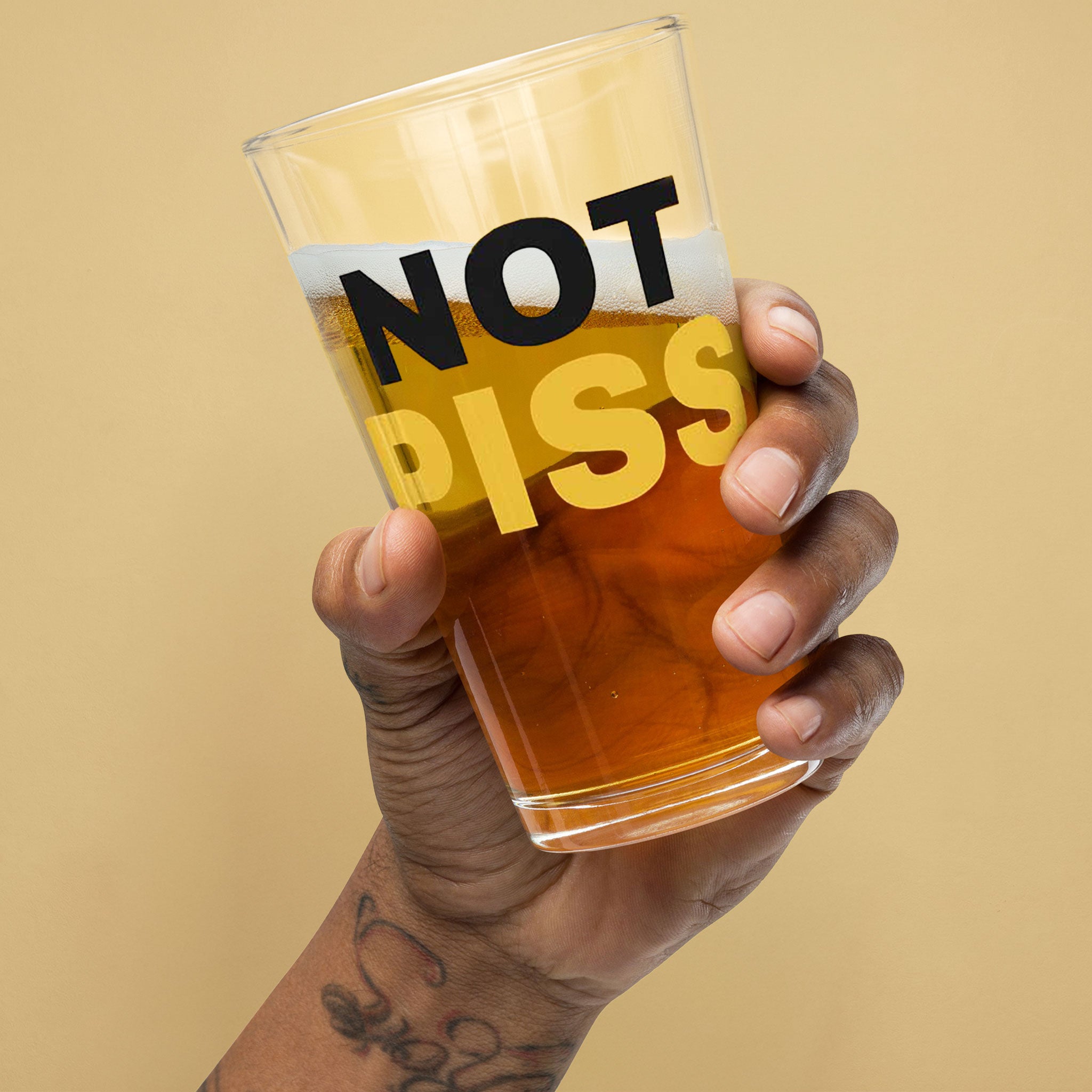 hand holding a half full NOT PISS pint glass - watersports kink pride LGBTQ+ glass by BackRoomGear