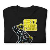 Folded black t-shirt with a man in rubber with yellow helmet and shoes sitting on top of a square barrel of piss design on a beige background - Black and yellow Sexy Rubber Flanders t-shirt - kinky latex rubber kink tee by BackRoomGear