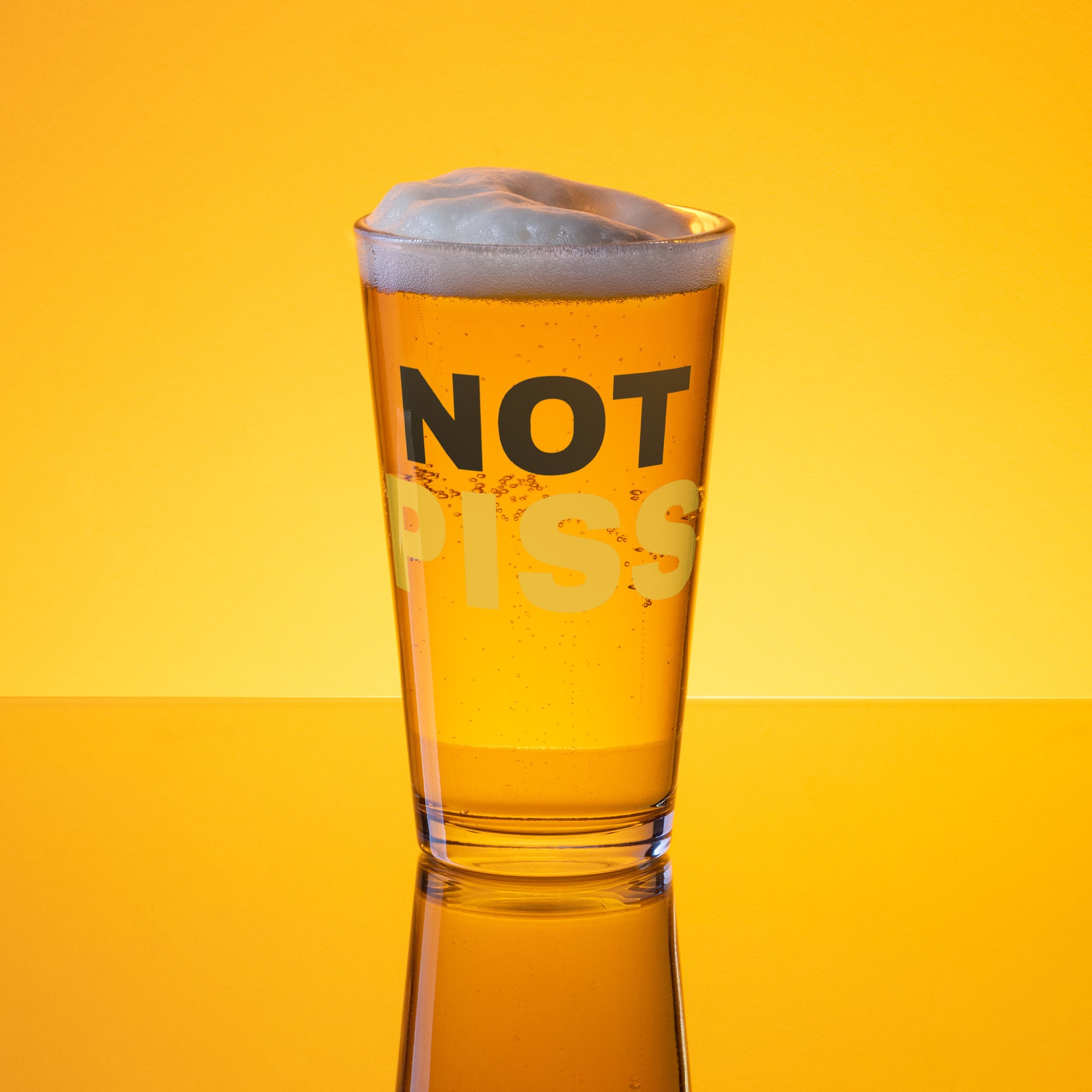 A pint glass with the text 'NOT PISS' printed on it, filled with a beverage, presented against an yellow background NOT PISS pint glass - watersports kink pride LGBTQ+ glass by BackRoomGear