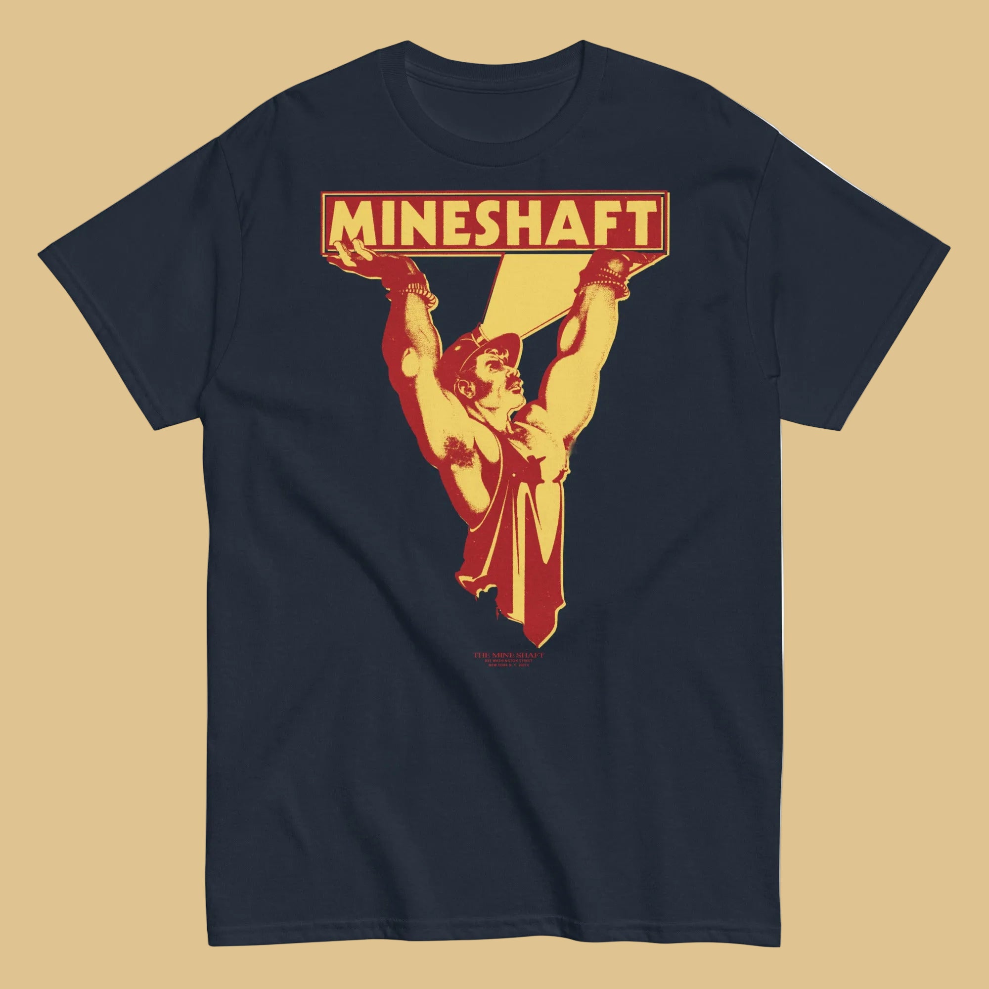 Navy t-shirt with 'MINESHAFT' graphic design on a beige background - Retro LGBTQ+ pride t-shirts US UK – Gay pride shirts collection – Made-to-order gay apparel