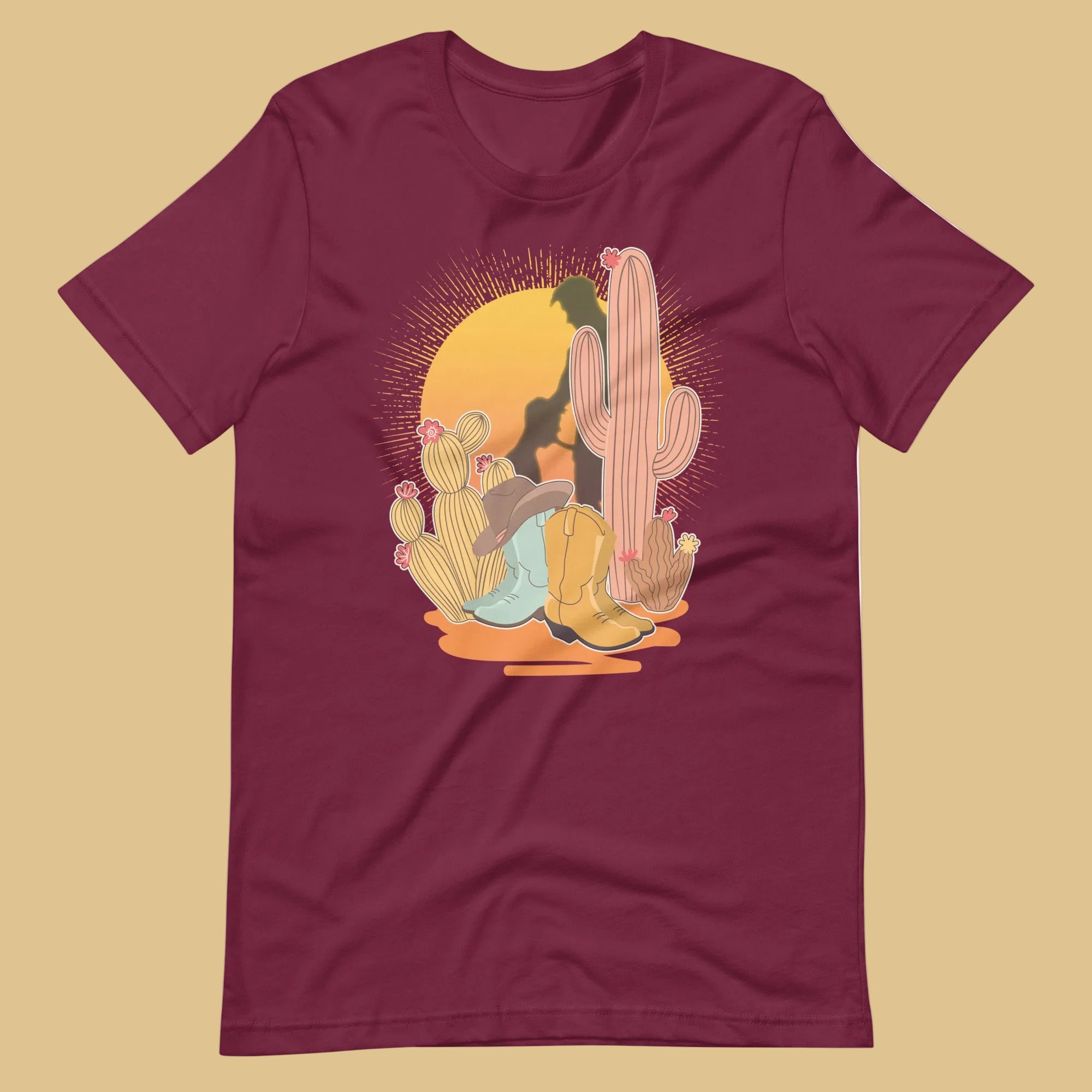 Maroon shirt featuring a sunset with two silhouetted figures, one sitting sucking the one standing, surrounded by cacti - Vintage Brokeback Cowboy t-shirt - western gay pride tee by BackRoom Gear