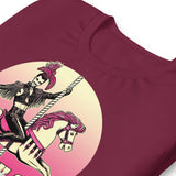 Closeup of maroon t-shirt with a graphic design of a leather-clad rider on a carousel pony, with the text 'PINK PONY CLUB' above the graphic - Pink Pony Club T-Shirt – LGBTQ+ Leather Pride Gay Tee – Gay pride shirts collection – LGBTQ+ pride t-shirts US UK – Made-to-order gay apparel