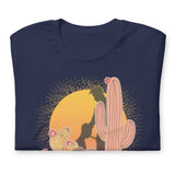 Folded navy blue shirt featuring a sunset with two silhouetted figures, one sitting sucking the one standing, surrounded by cacti - Vintage Brokeback Cowboy t-shirt - western gay pride tee by BackRoom Gear
