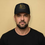 Gay man wearing Happy Little Cigar Pig trucker cap with cartoon pig smoking cigar graphic on black mesh snapback hat - Backroom Gear