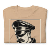 Folded tan T-shirt with a graphic design of a mustachioed man in classic leather gear - Tan Leather Icon t-shirt - leather daddy gay pride LGBTQ+ tee by BackRoomGear